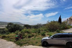 a car parked next to a motorcycle on the side of a road at Luxury en-suite Double. Beach-house with Sea Views in Mellieħa