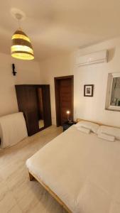 a bedroom with a large white bed and a light at Luxury en-suite Double. Beach-house with Sea Views in Mellieħa