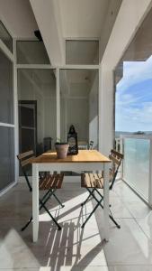 a table on a balcony with a view of the ocean at Luxury en-suite Double. Beach-house with Sea Views in Mellieħa