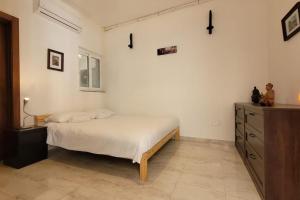 a bedroom with a bed and a dresser in it at Luxury en-suite Double. Beach-house with Sea Views in Mellieħa