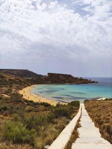 eine unbefestigte Straße, die zum Strand mit dem Meer führt in der Unterkunft Luxury en-suite Double. Beach-house with Sea Views in Mellieħa