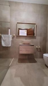 a bathroom with a sink and a mirror and a toilet at Luxury en-suite Double. Beach-house with Sea Views in Mellieħa