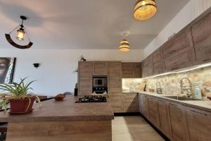 a large kitchen with wooden cabinets and a counter top at Luxury en-suite Double. Beach-house with Sea Views in Mellieħa
