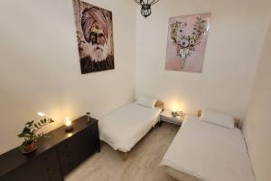 a room with two beds and a desk with candles at Luxury en-suite Double. Beach-house with Sea Views in Mellieħa