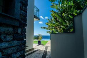 a door to a house with a view of the ocean at Infinite Ocean View Villa 20m above Ocean & Beach in Arco da Calheta