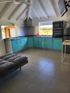 a kitchen with blue cabinets and a couch in a room at Les gîtes de Macca in Saint-François