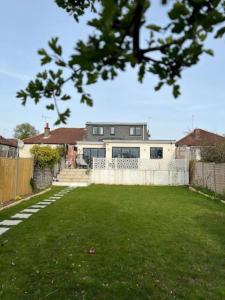 a house with a lawn in front of it at Modern Family Home in Greater London in Pinner