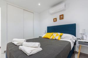 贝尼多姆VIRGINIA Levante beach apartments的一间卧室配有黄色和白色枕头的床