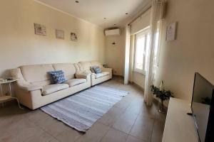 a living room with a white couch and a television at Oeiras Historic Bedrooms in Oeiras