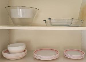 three plates and bowls are sitting on a shelf at Oeiras Historic Bedrooms in Oeiras