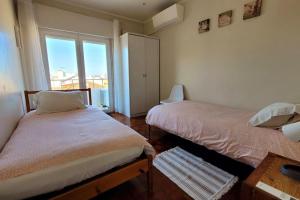 1 dormitorio con 2 camas y ventana en Oeiras Historic Bedrooms, en Oeiras
