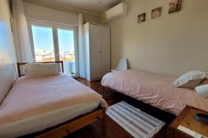Un dormitorio con dos camas y una ventana. en Oeiras Historic Bedrooms, en Oeiras
