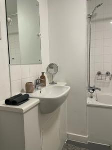 a white bathroom with a sink and a shower at Spacious Flat in Manor House, London in London