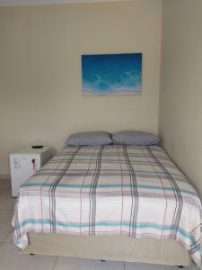Schlafzimmer mit einem Bett mit Wandgemälde in der Unterkunft Suíte Porto das Dunas in Salvador