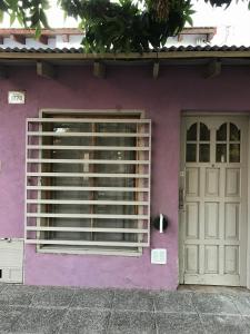 una casa púrpura con una puerta y una puerta en Depto Céntrico tipo dúplex General Roca en General Roca