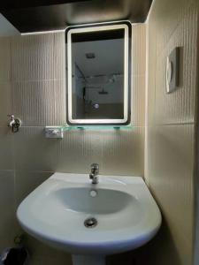 ein Badezimmer mit einem weißen Waschbecken und einem Spiegel in der Unterkunft Affordable Condo Unit in a Prime and Five-Star Location in Manila