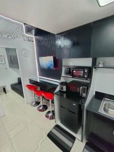 eine Küche mit roten Barhockern in einem Zimmer in der Unterkunft Affordable Condo Unit in a Prime and Five-Star Location in Manila