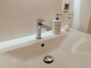 a white sink with a soap dispenser on it at Nowy w centrum 2 in Giżycko