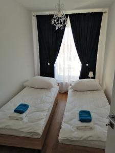 two beds in a room with a window at Nowy w centrum 2 in Giżycko