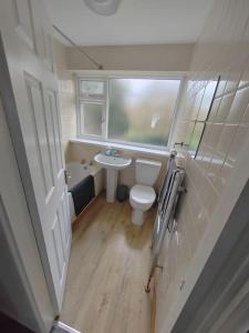 a bathroom with a toilet and a sink and a window at Cosy Brighouse 3 bed house-Great for contractors in Brighouse