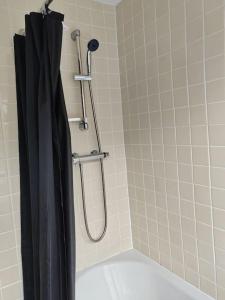 a shower with a black shower curtain in a bathroom at Cosy Brighouse 3 bed house-Great for contractors in Brighouse