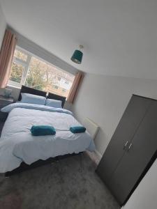 um quarto com uma cama, uma cómoda e uma janela em Cosy Brighouse 3 bed house-Great for contractors em Brighouse