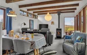 ein Wohnzimmer mit einem Tisch, Stühlen und einem Kamin in der Unterkunft Amazing Home In Stege With Kitchen in Stege