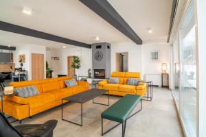 a living room with two yellow couches and a table at Country house Greenfields in Gospić