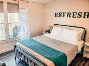 ein Schlafzimmer mit einem Bett mit einem Schild an der Wand in der Unterkunft Tucky Cabin - Riverfront Getaway in Fentress McMahan