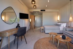 Habitación de hotel con cama y espejo en Mayu Suites en Pyrgos