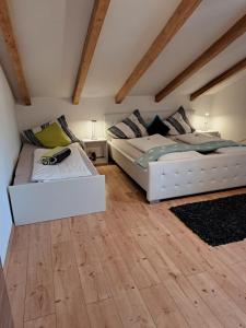 2 Betten in einem Zimmer mit Holzböden in der Unterkunft Appartement Fortuna in Saalfelden am Steinernen Meer