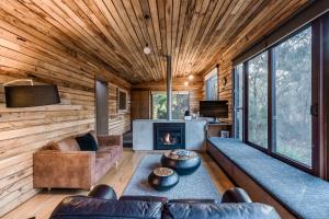 sala de estar con sofá y chimenea en DULC Cabins, en Halls Gap