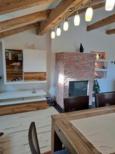 a living room with a brick fireplace and a tv at Appartement Fortuna in Saalfelden am Steinernen Meer