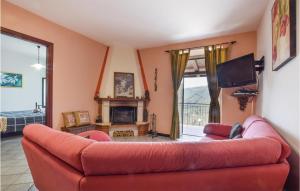 sala de estar con sofá rojo y chimenea en Beautiful Home In Librizzi With Outdoor Swimming Pool, en Librizzi