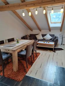 ein Wohnzimmer mit einem Holztisch und einem Sofa in der Unterkunft Appartement Fortuna in Saalfelden am Steinernen Meer