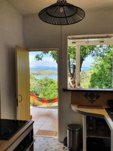 une cuisine avec une porte ouverte sur une terrasse offrant une vue. dans l'établissement Villa Sunshine, à La Trinité