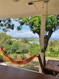 a hammock on a porch with a view of the water at Villa Sunshine in La Trinité