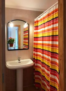 ペニスコラにあるSea Home Peñiscolaのバスルーム(シンク、カラフルなシャワーカーテン付)
