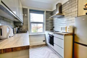a kitchen with white appliances and a window at Amazing 2 bed London apartment in London