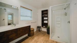 a bathroom with a shower and a sink and a mirror at Lakes Edge Holiday Park in Lake Tekapo +72 photos