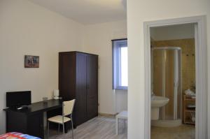 - une chambre avec un bureau et une salle de bains pourvue d'un lavabo dans l'établissement B&B Preludio, à Nova Siri Marina
