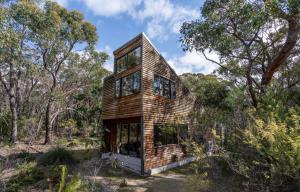 una casa de madera en el bosque con árboles en DULC Cabins, en Halls Gap