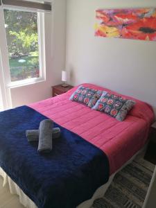 a bedroom with a bed with a towel on it at Departamento Pucón Nativo in Pucón