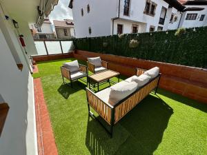 a patio with two couches and a table and chairs at Apartamento Plaza del Rey in Santillana del Mar