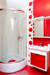 a red and white bathroom with a shower and a sink at Modern Penthouse Apartment in Bitola in Bitola