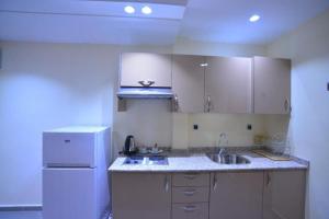 a kitchen with a white refrigerator and a sink at RESIDENCE CENTROSUIT in Laayoune +19 photos