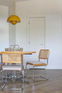 a table and chairs in a room with a yellow light at The Dairy . Margaret River in Margaret River Town