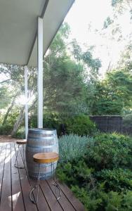 a barrel sitting on a deck with a table and chairs at The Dairy . Margaret River in Margaret River Town