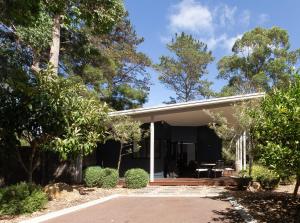 a house with a porch and trees in front of it at The Dairy . Margaret River in Margaret River Town