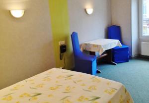 een ziekenhuiskamer met een bed en twee tafels bij La Boule d'Or in Bressuire